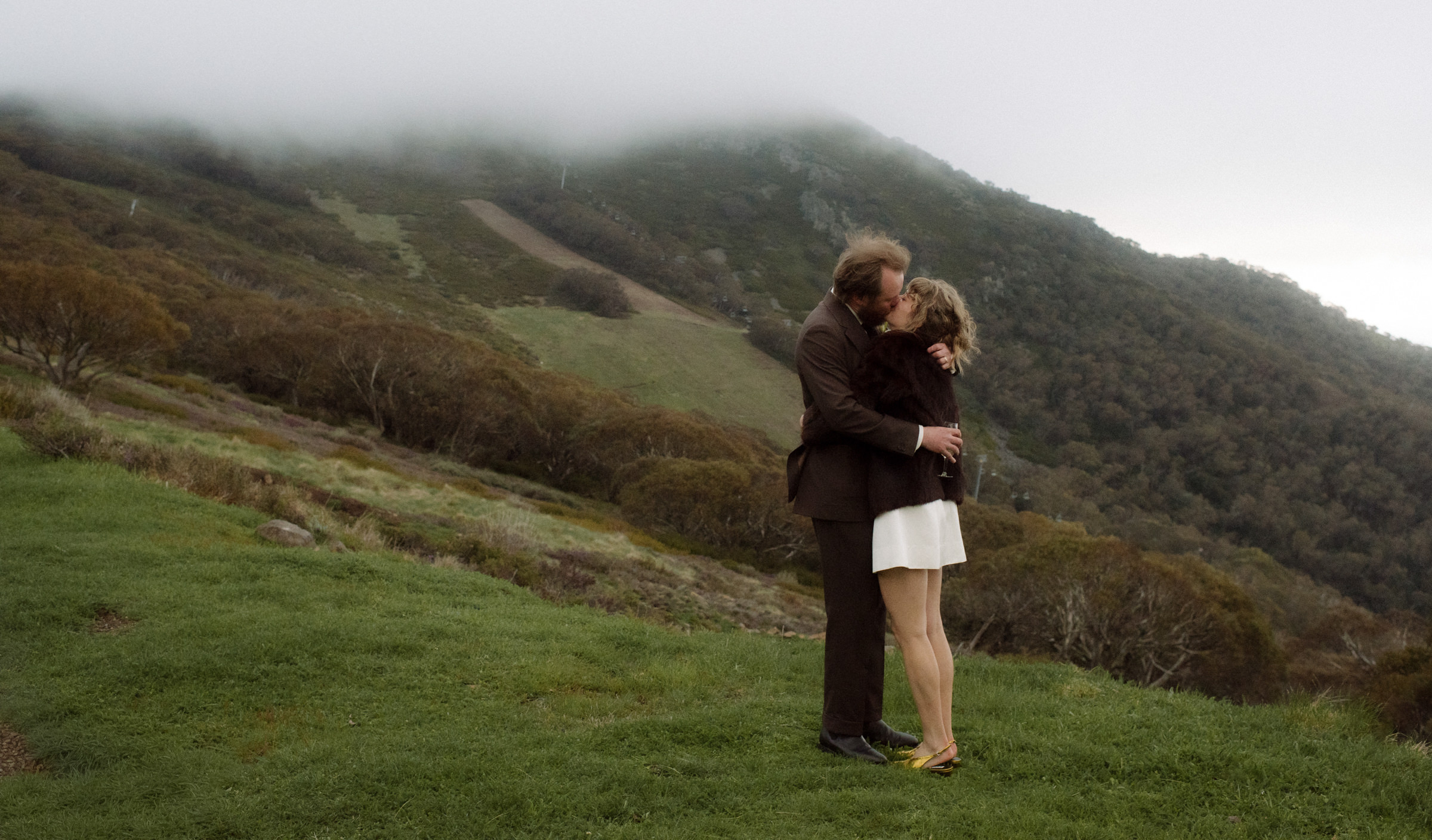 couple kissing on misty mountain top