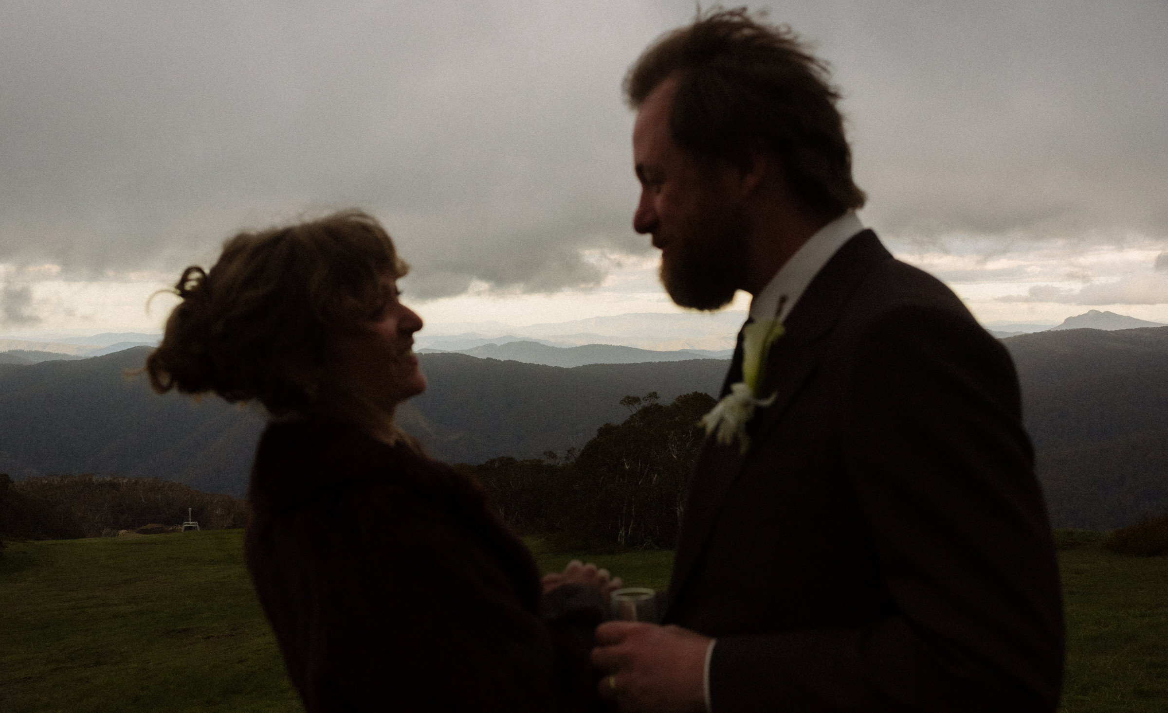 a couple share an embrace during their portrait session on a mountain top in the clouds