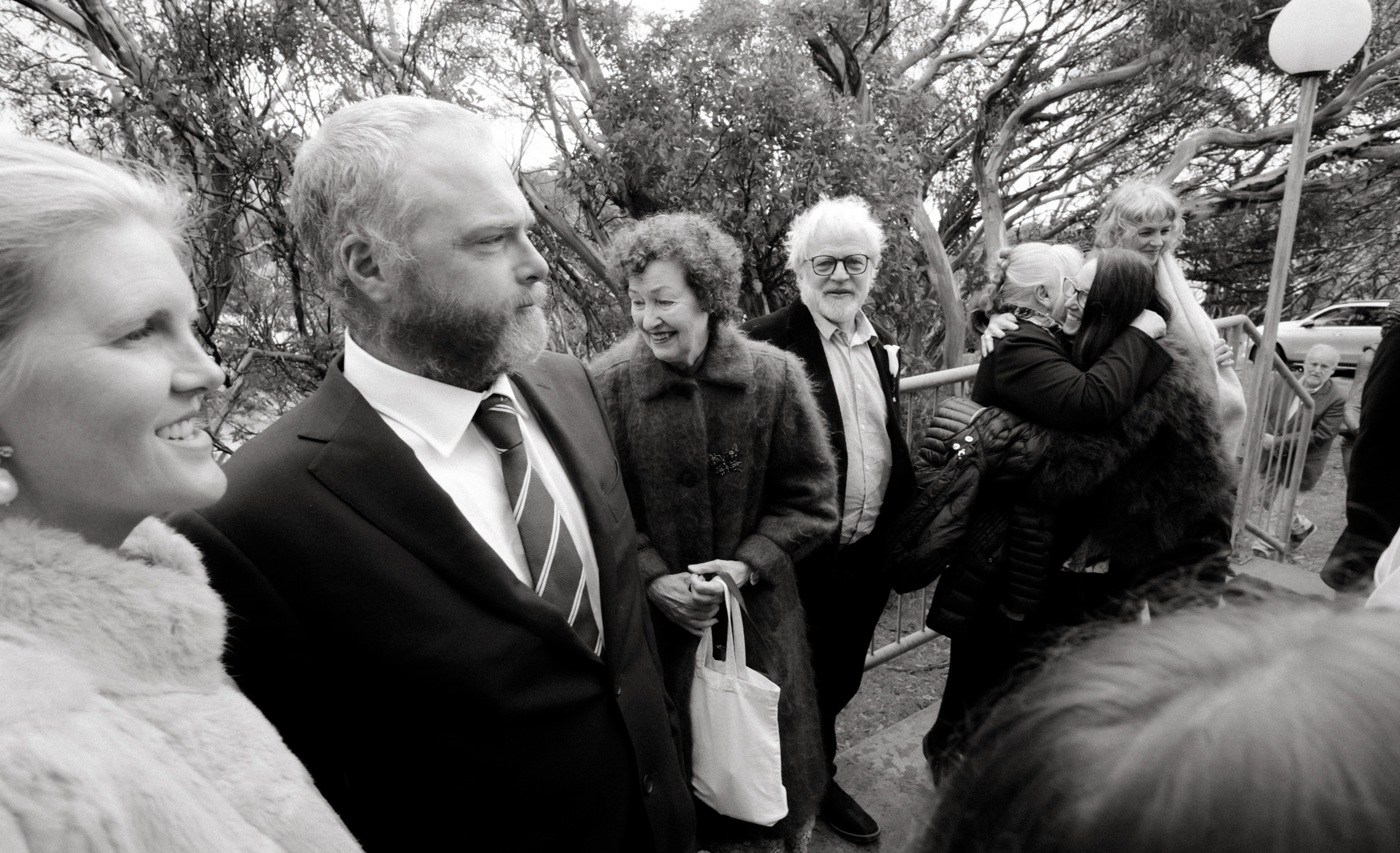 a black and white image of guests after wedding ceremony