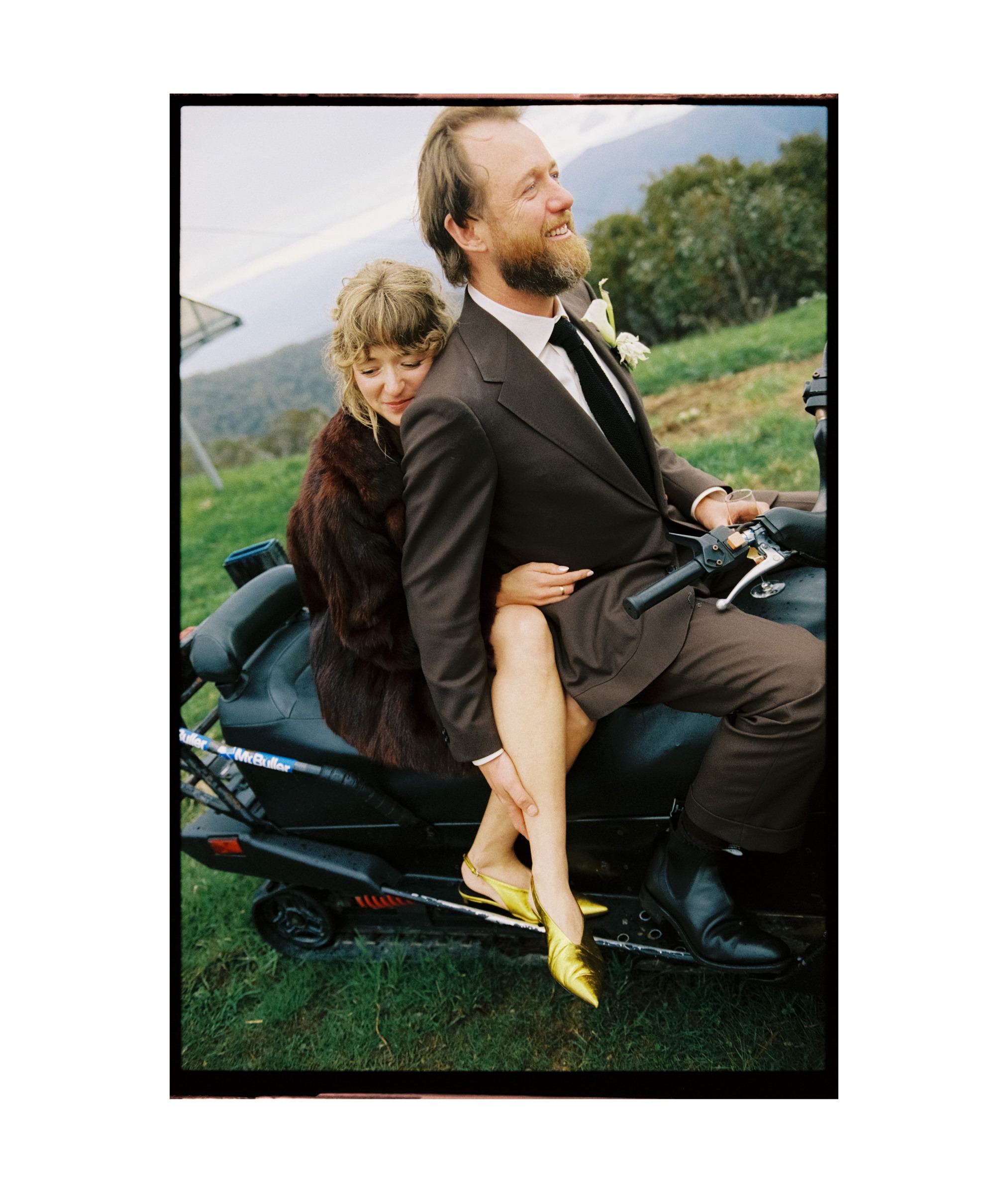 a film photo of a couple embracing on a snow mobile