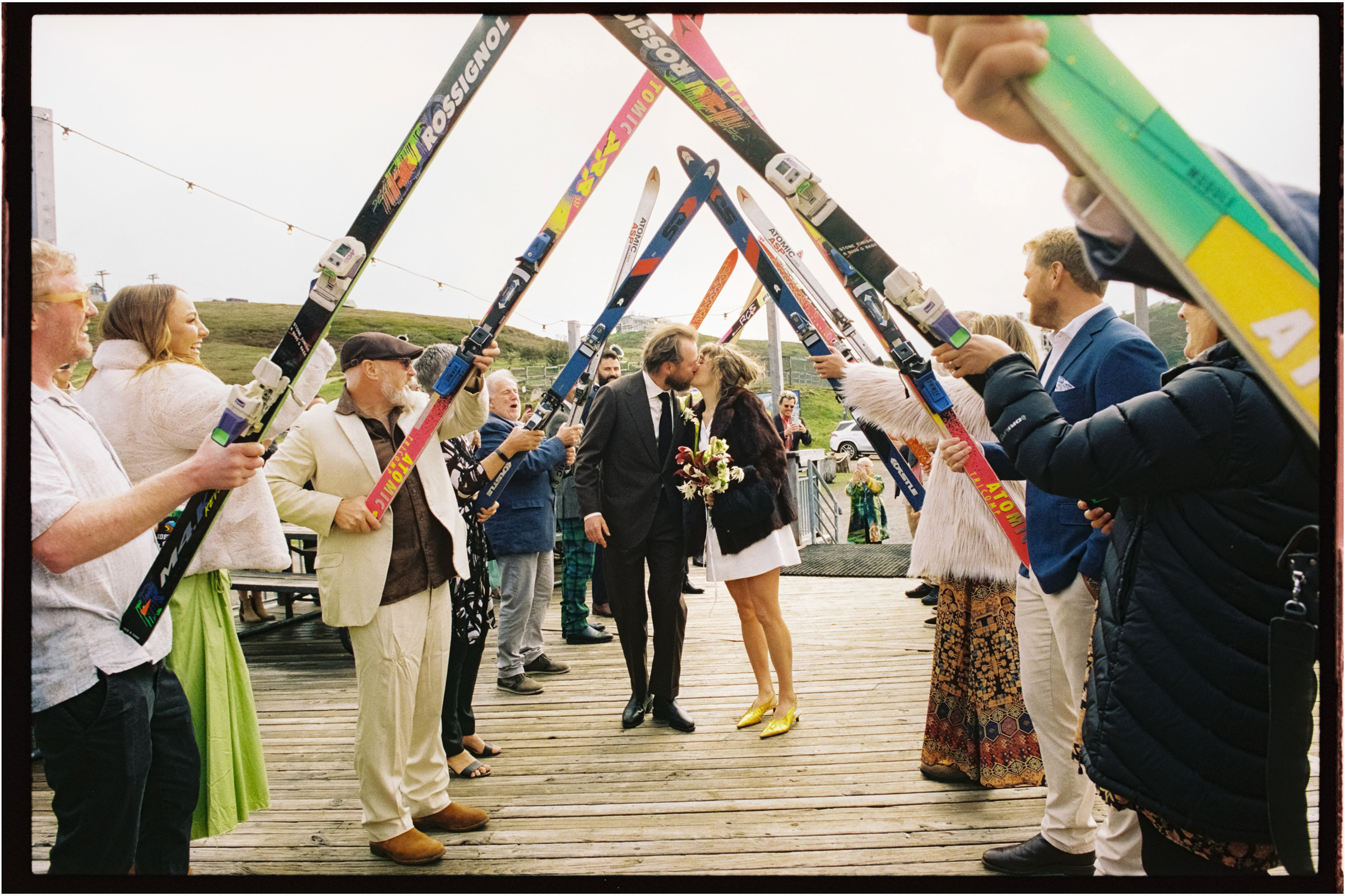 a couple enter their wedding reception under a guard of honour of skis