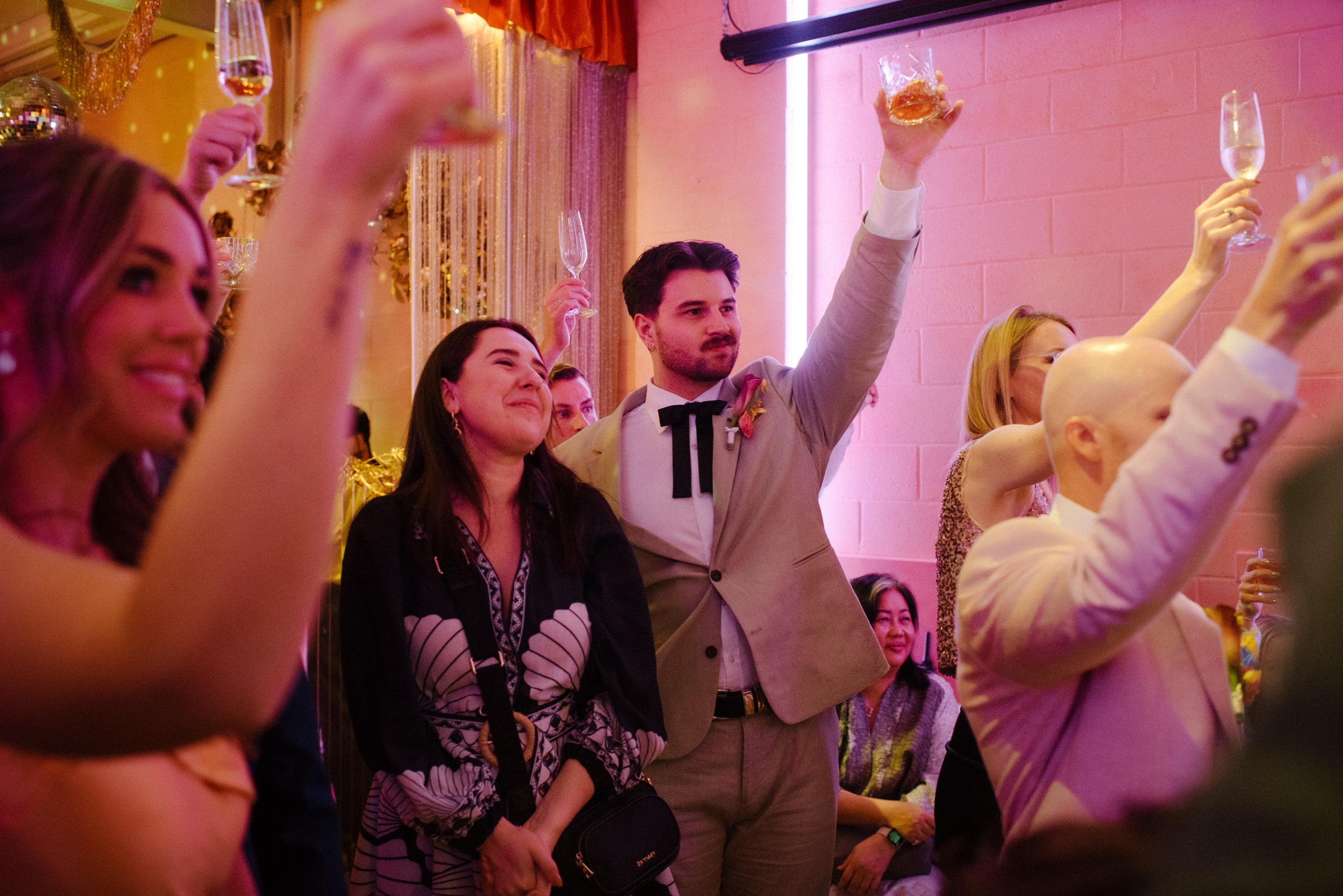 guests raise a cheers to the bride and groom