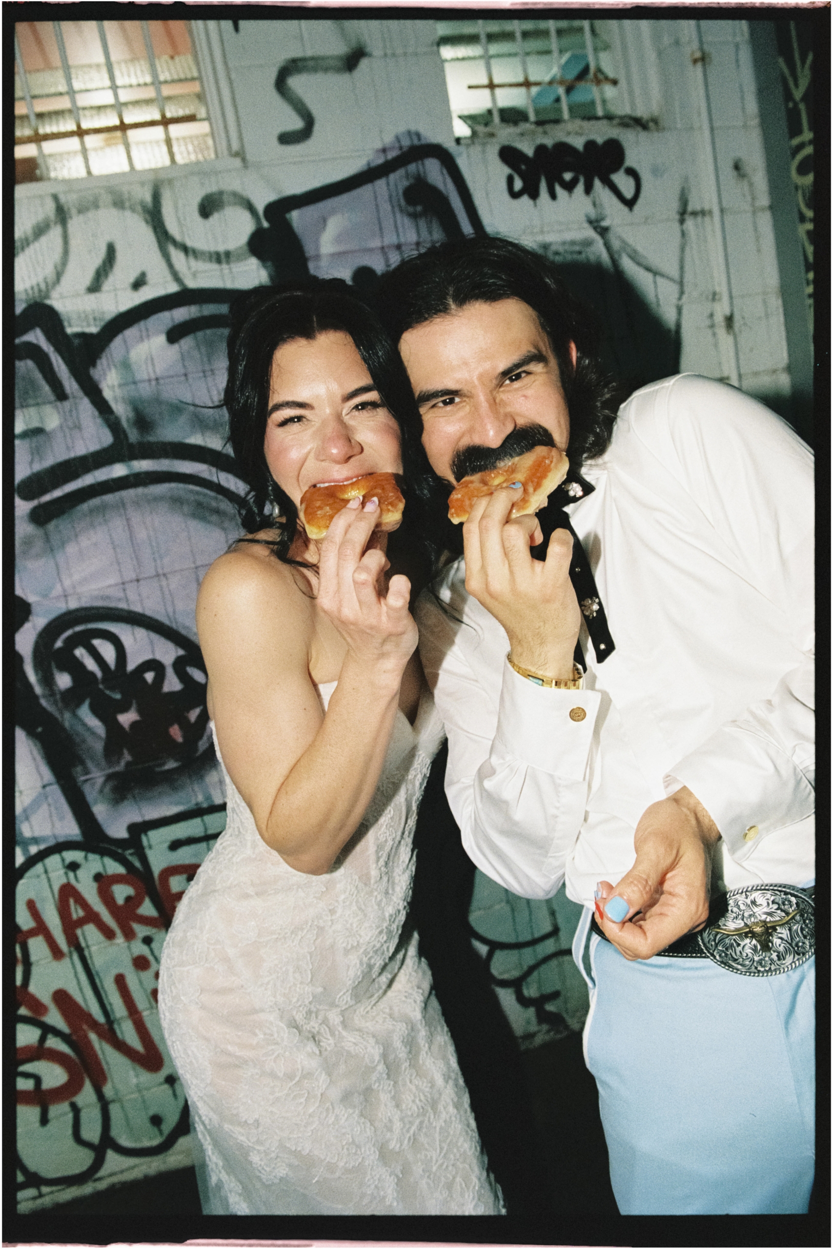 the couple enjoy some donuts out the back of their wedding reception
