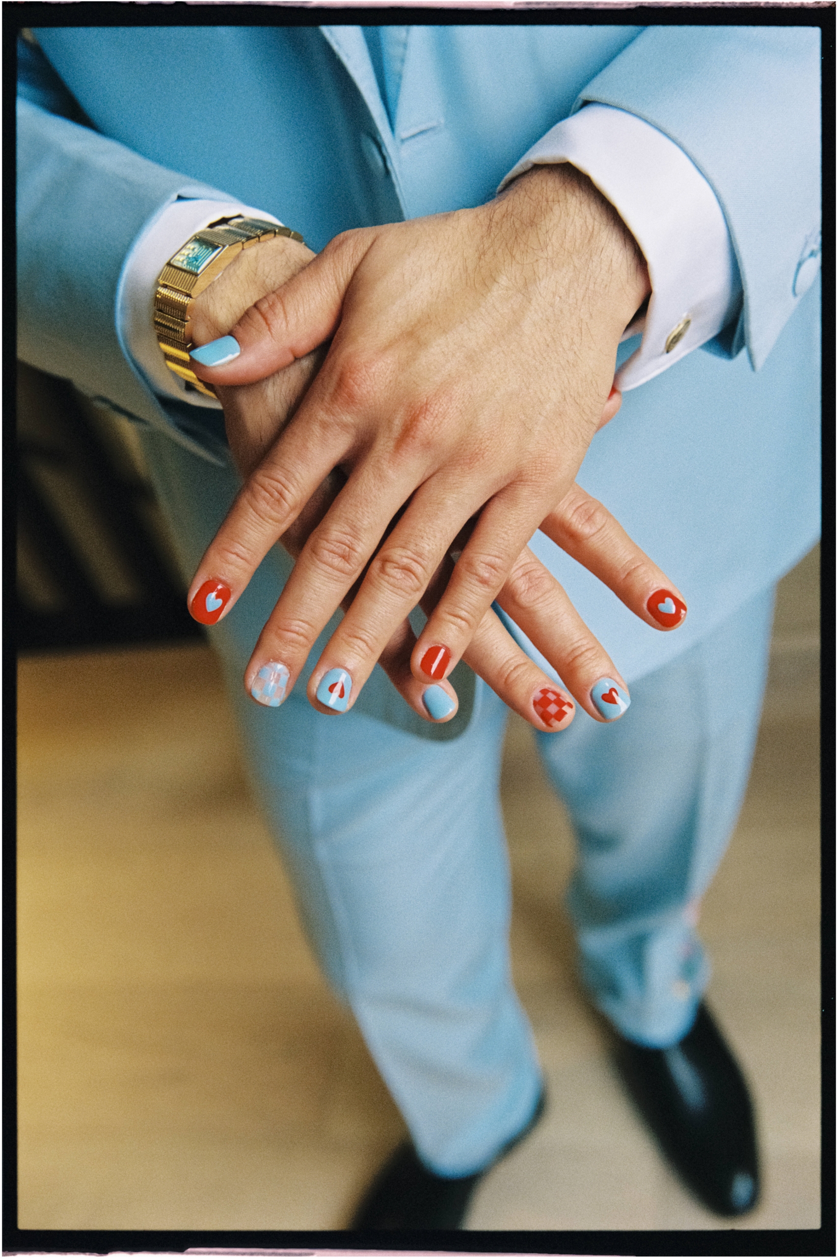 a film photo of the groom's designer nail polish